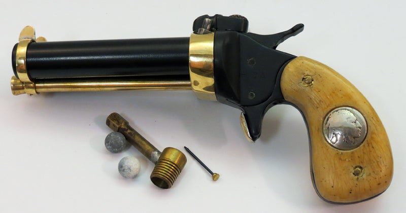 Accessories with the Model MC include a couple old round balls, a powder measure, and the little tool for releasing the ramrod. Photo © Russ Chastain