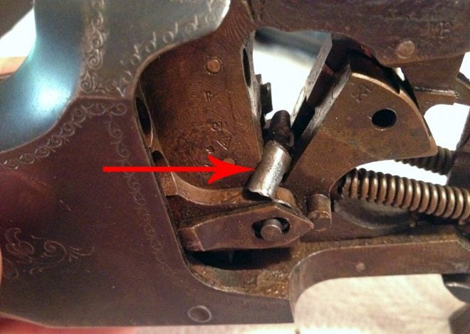 The arrow shows part of the broken firing pin blocking the hammer. I hate it when that happens! (Photo © Russ Chastain)