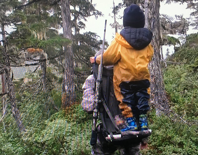 Eivin Kilcher carries his son Findlay on a backpack while hunting.