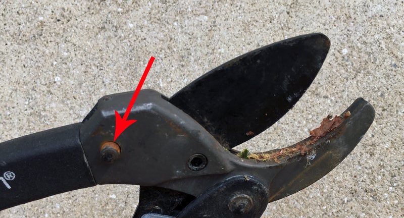 Hooyman Ratchet Pruner. Groove in bottom jaw fills with bark and debris. Saw detach plunger (arrow) lacks spring tension.