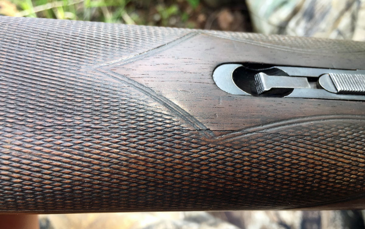 A crack runs almost the entire length of the forend. Note how worn the checkering is. (Photo © Russ Chastain)