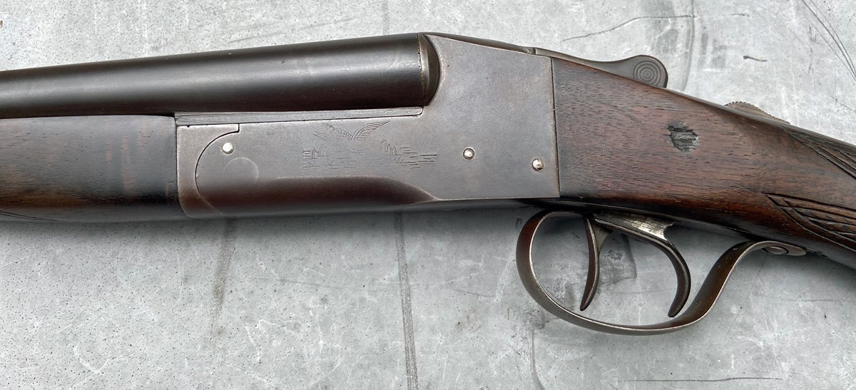 This old scattergun has the same engraved scene on both sides, mostly worn away. That gouge in the stock appeared ancient 40+ years ago when I first saw this gun. (Photo © Russ Chastain)