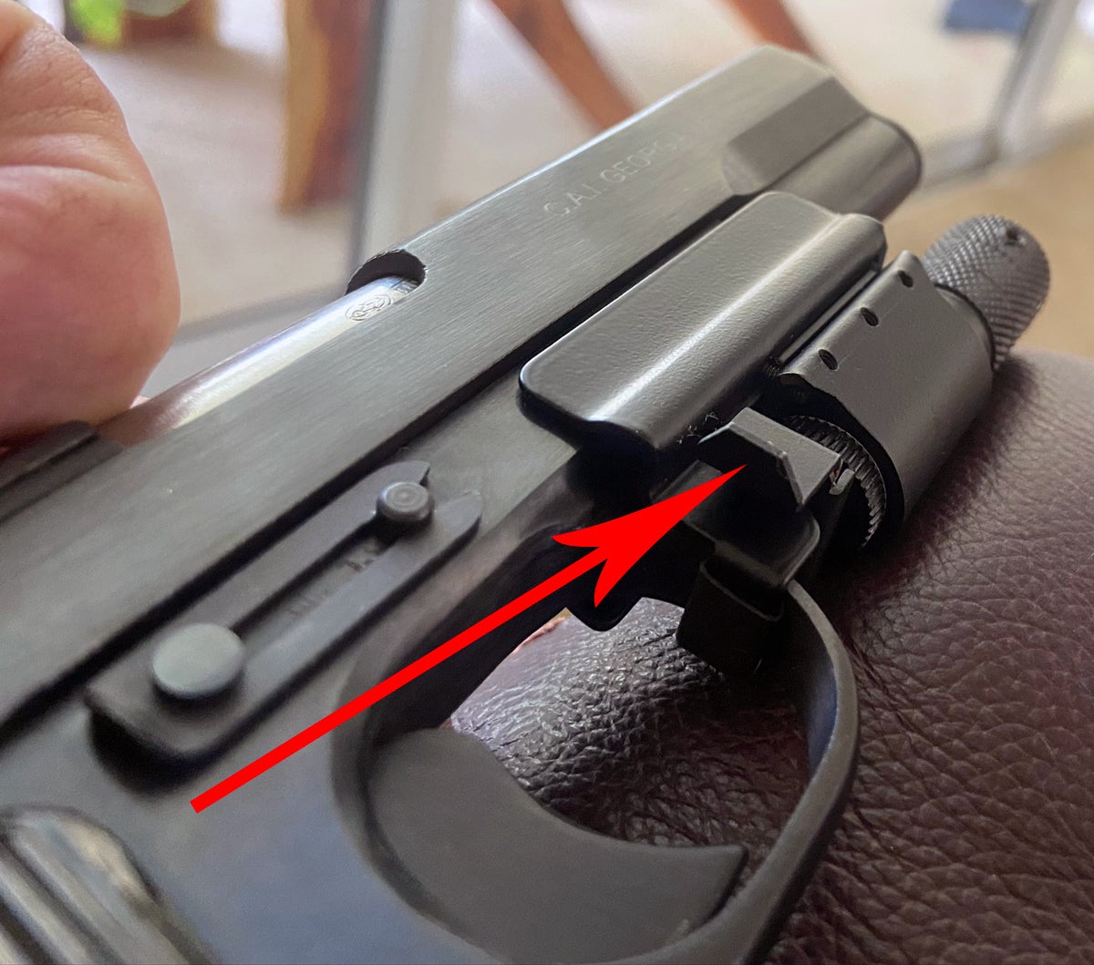 No notch in the rear sight? Add a laser! This magnetic-mount Ramlite laser is interesting. Arrow points to the paddle; press it forward to switch on the red laser. (Photo © Russ Chastain)