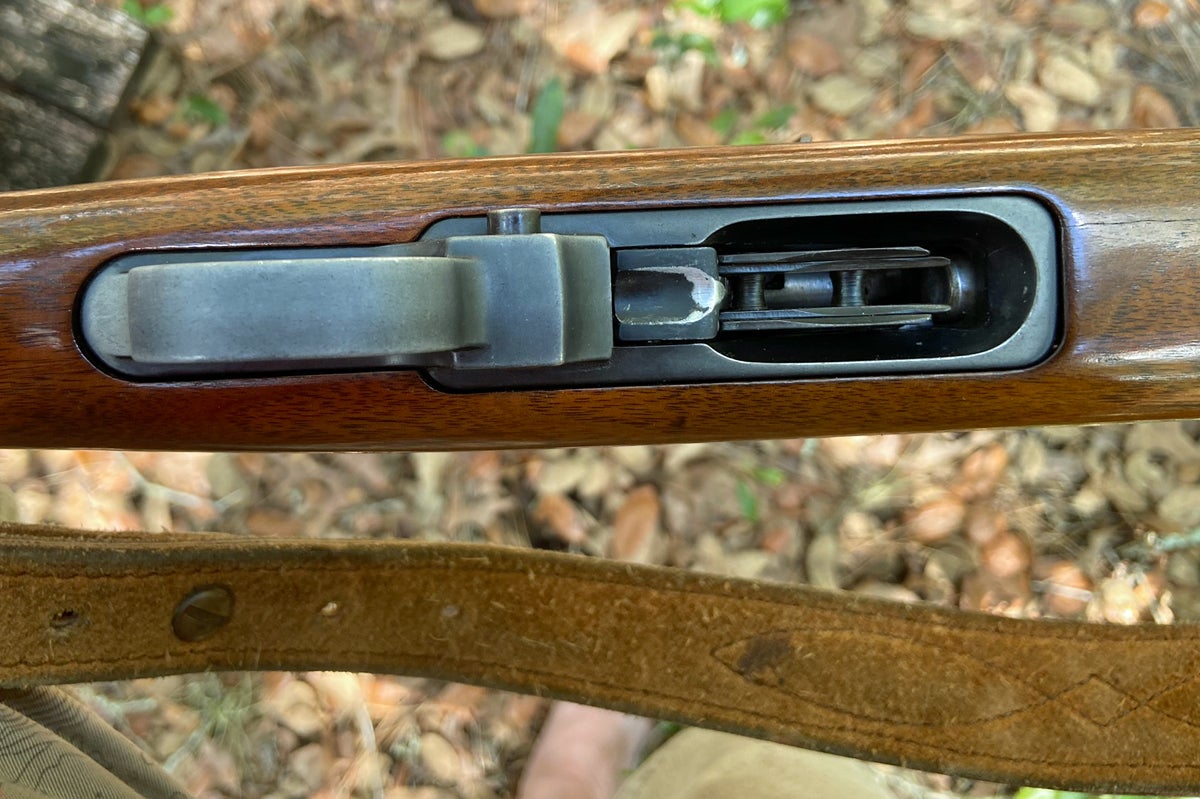 Silver shows where paint has been worn from the button which must be depressed to load the rifle or to release the bolt. The suede sling wears a bit of pine sap from one of the many trees I climbed with this rifle. (Photo © Russ Chastain)