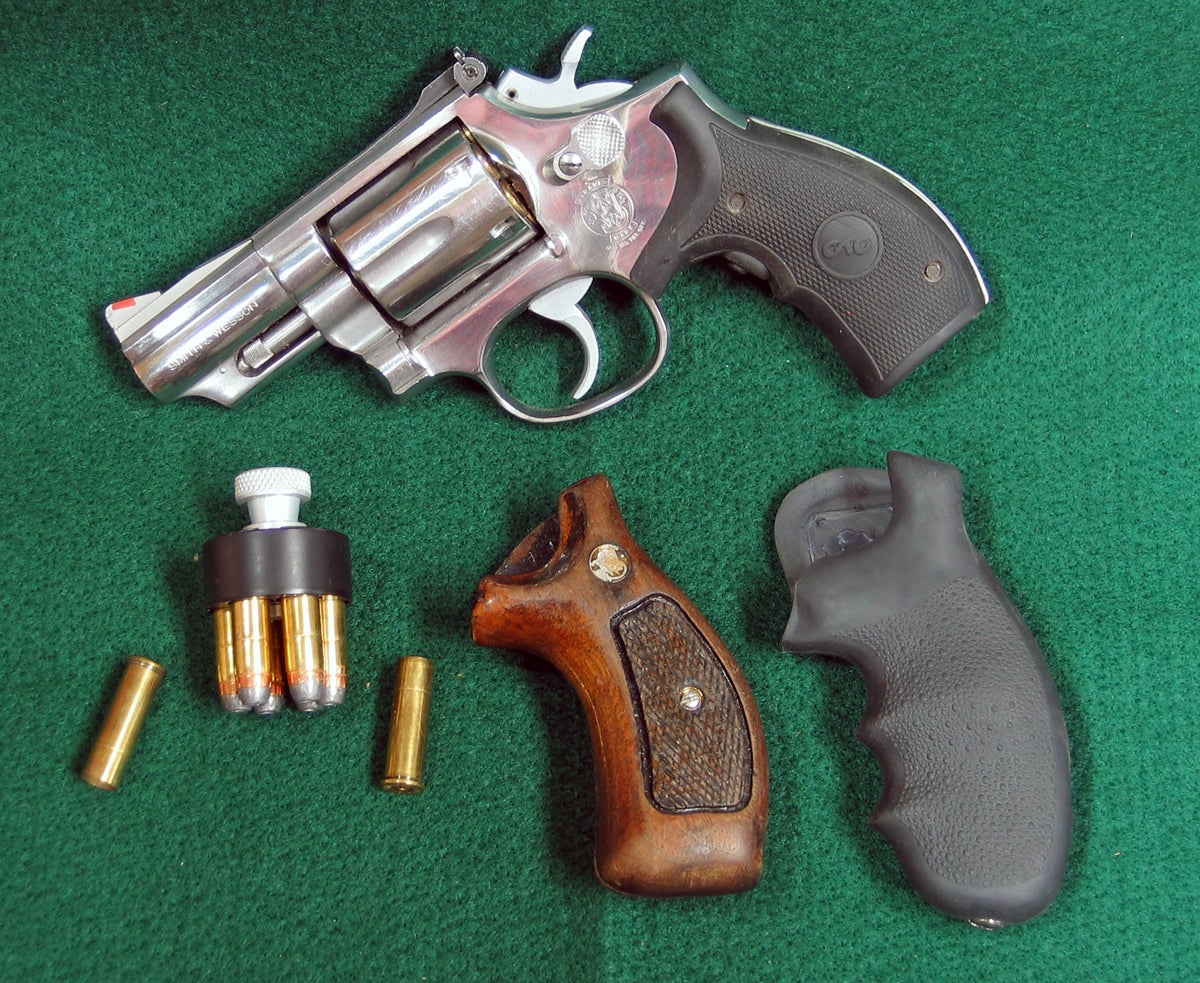 S&W Model 66-2 revolver with speed loader, extra grips, and a couple empty shells. (Photo © Russ Chastain)