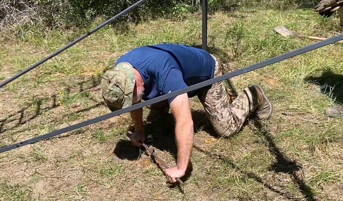 Our friend Hunter helped screw in the ground anchor. (Photo © Russ Chastain)