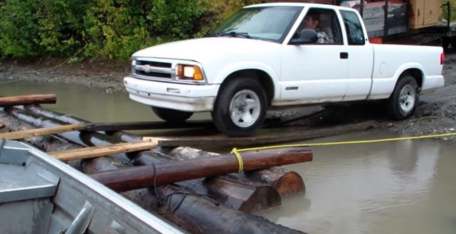 Stan Zuray of Yukon Men Moving a Pickup Truck on a Log Raft