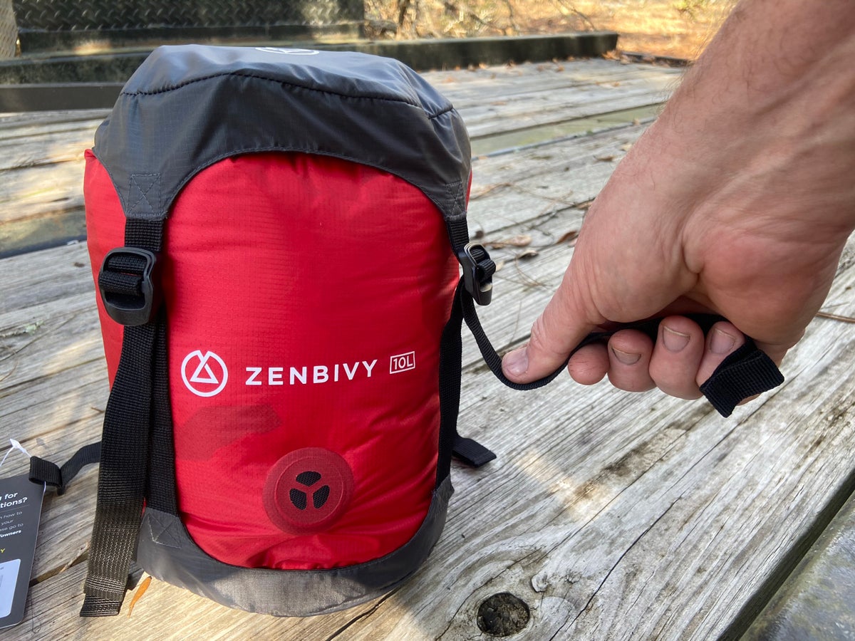 Compressing the Dry Sack. For full compression, it helps to push down with your other hand or a knee. (Photo © Russ Chastain)